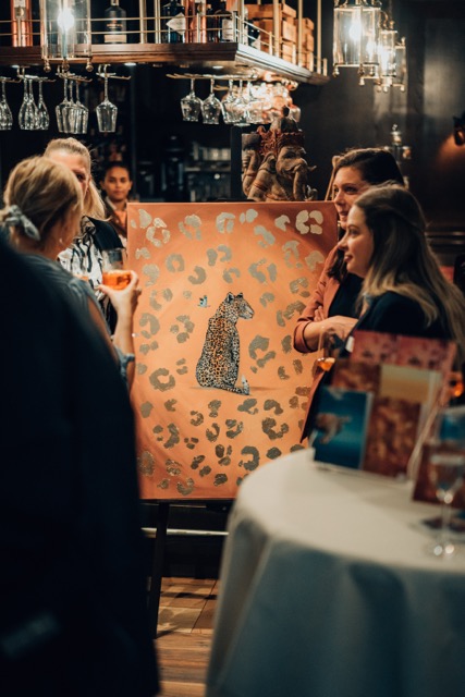Gäste betrachten ein Gemälde mit Leoparden-Motiv im Park-Hotel Hagenbeck