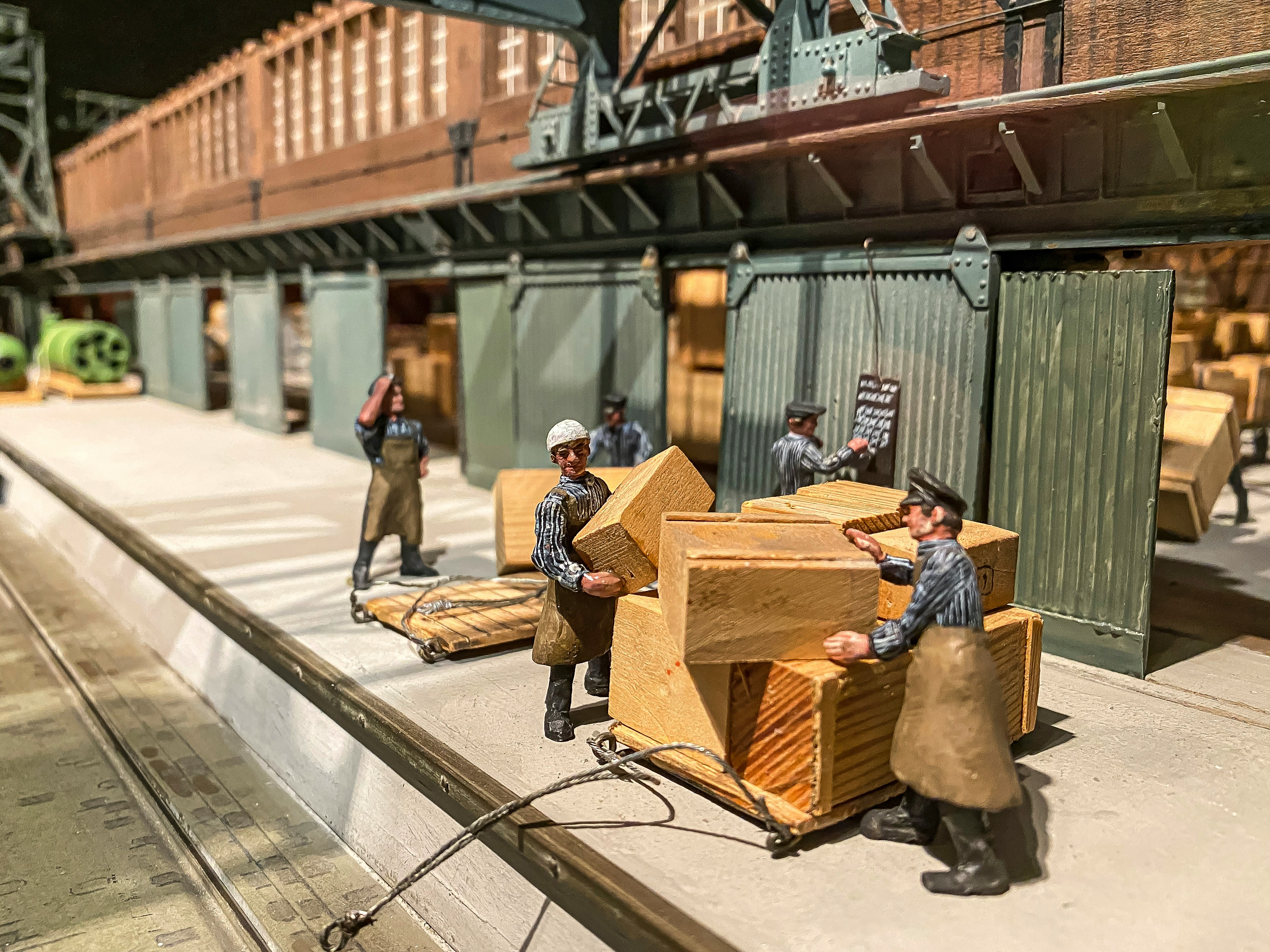 Detailreiche Hafenszene im Miniaturmuseum mit kleinen Figuren und Warenkisten