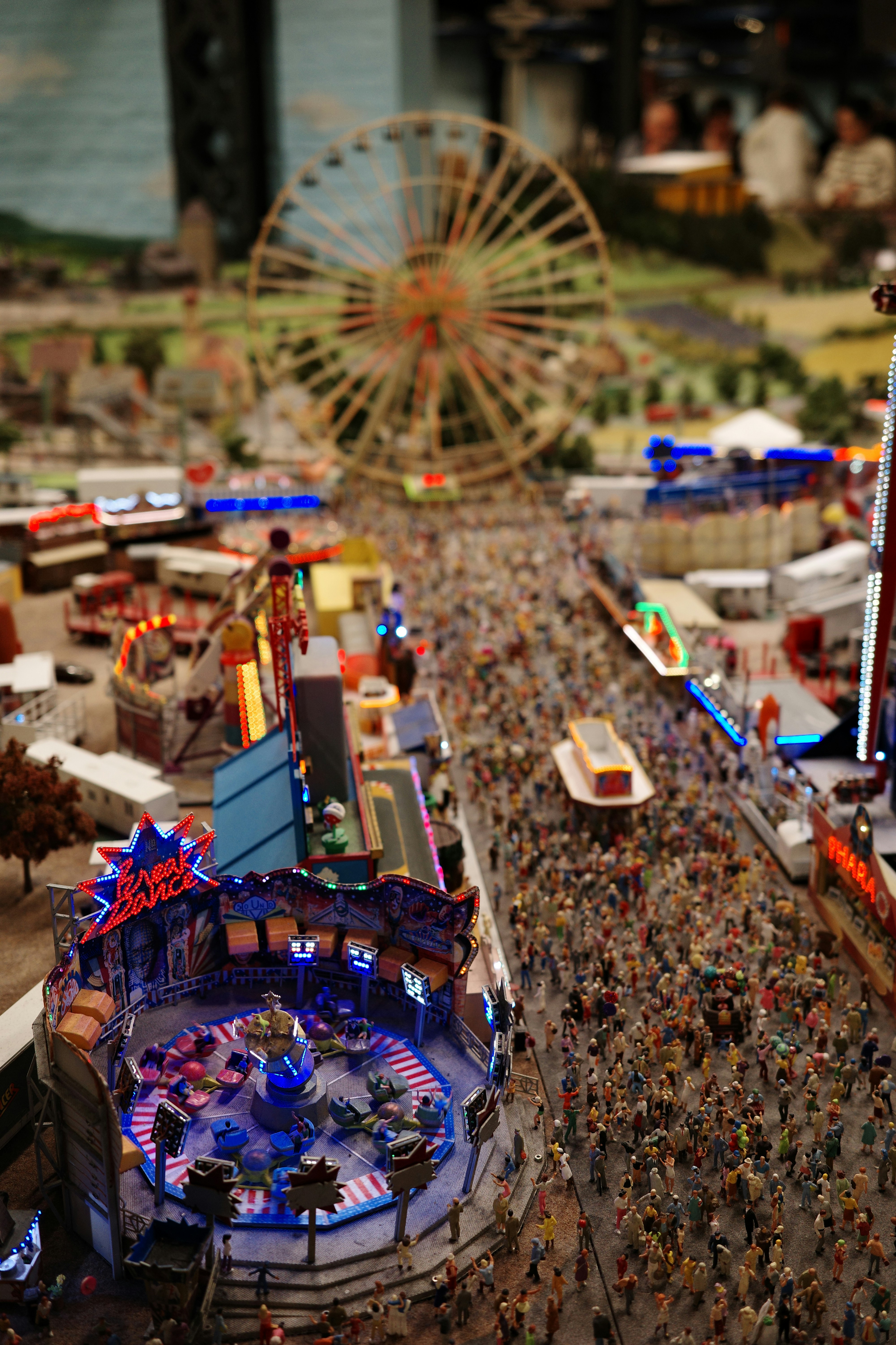 Miniaturansicht einer vollbesuchten Kirmes mit Breakdancer im Fokus.