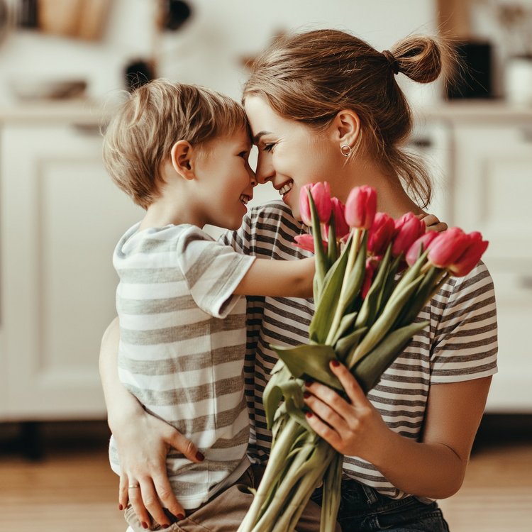 Ein Junge schenkt seiner Mutter einen Strauß Tulpen