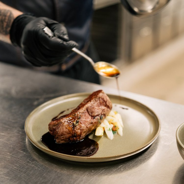 Finely plated meat dish at Park-Hotel Hagenbeck – finished with sauce by the chef