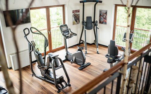 Heller Fitnessraum im Park-Hotel Hagenbeck mit modernen Cardio-Geräten und Ausblick ins Grüne