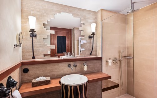 Exotisch inspiriertes Badezimmer im Park-Hotel Hagenbeck – Naturstein trifft Designkomfort