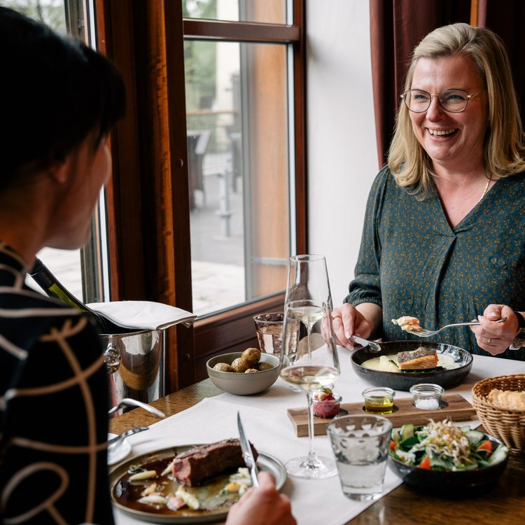 Zwei Frauen genießen ein entspanntes Abendessen im Restaurant des Park-Hotel Hagenbeck