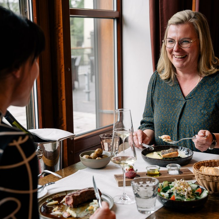 Zwei Frauen genießen ein entspanntes Abendessen im Restaurant des Park-Hotel Hagenbeck