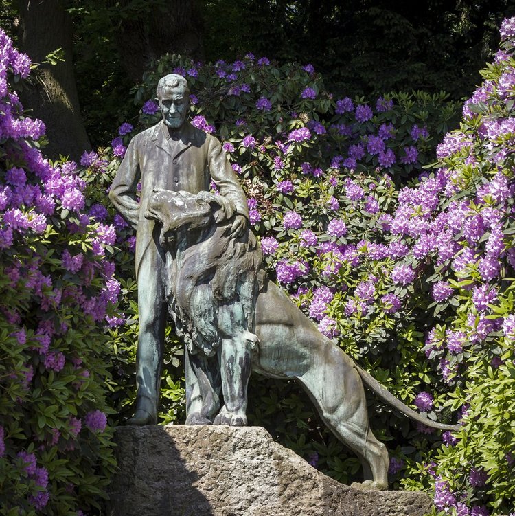 Carl-Hagenbeck-Denkmal zwischen lila Blüten direkt am Park-Hotel Hagenbeck in Hamburg