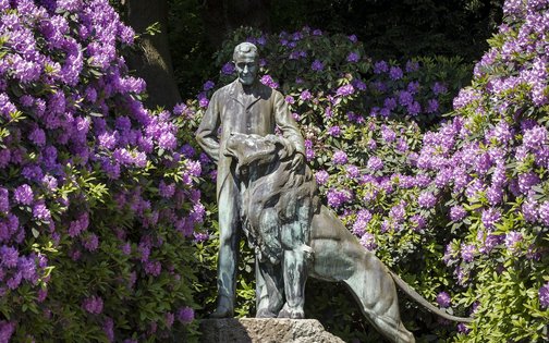 Carl Hagenbeck memorial surrounded by purple blossoms next to Park-Hotel Hagenbeck in Hamburg
