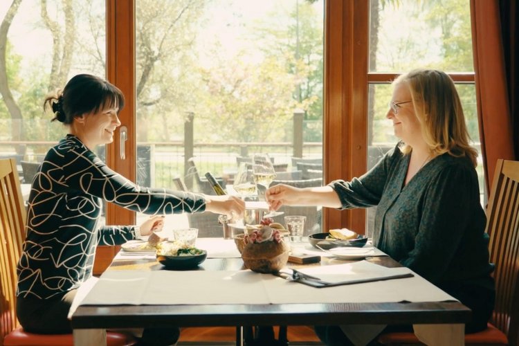 Two women enjoying a stylish breakfast at Park-Hotel Hagenbeck with a view of the greenery