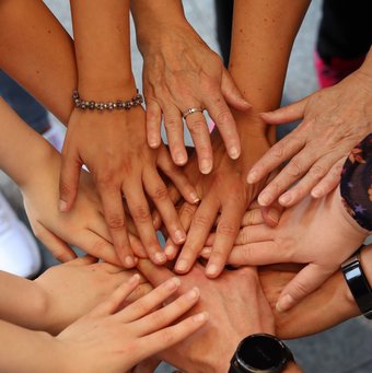 Hände übereinander gehalten: "Alle halten zusammen"