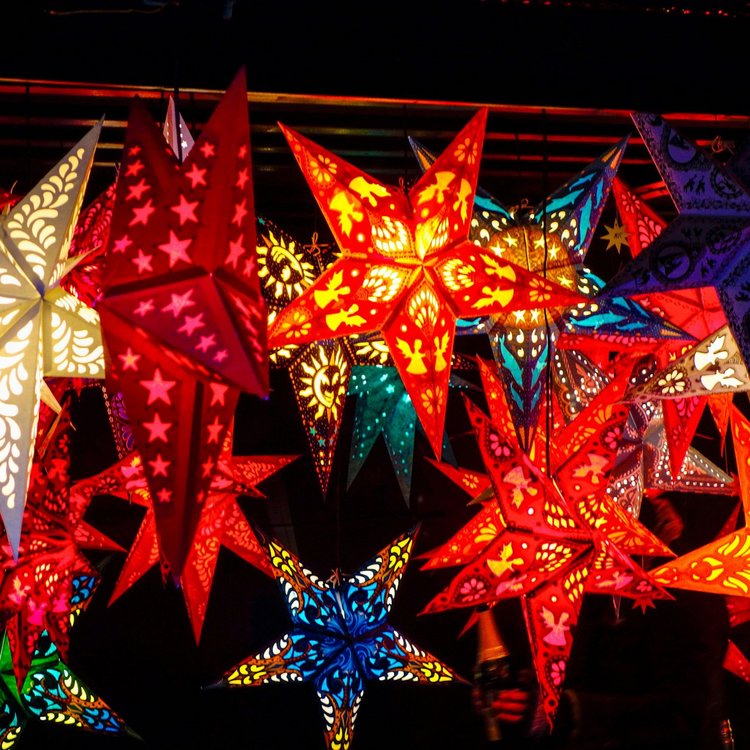 Leuchtende Deko-Sterne auf dem Hamburger Weihnachtsmarkt – bunte Papiersterne in verschiedenen Formen