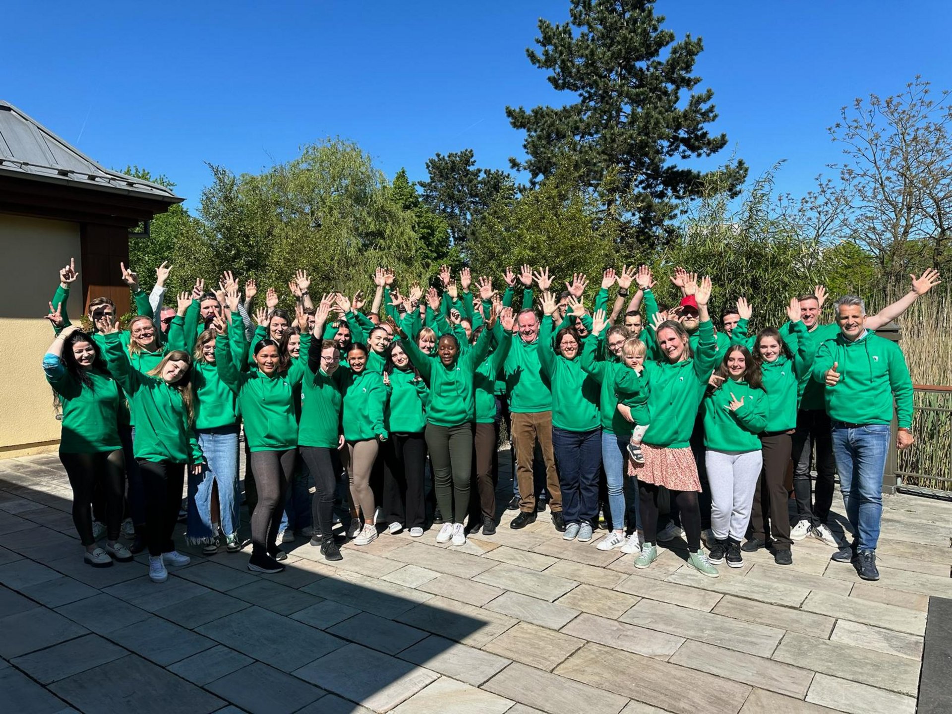 The Park-Hotel Hagenbeck team in green sweaters during a group photo outdoors