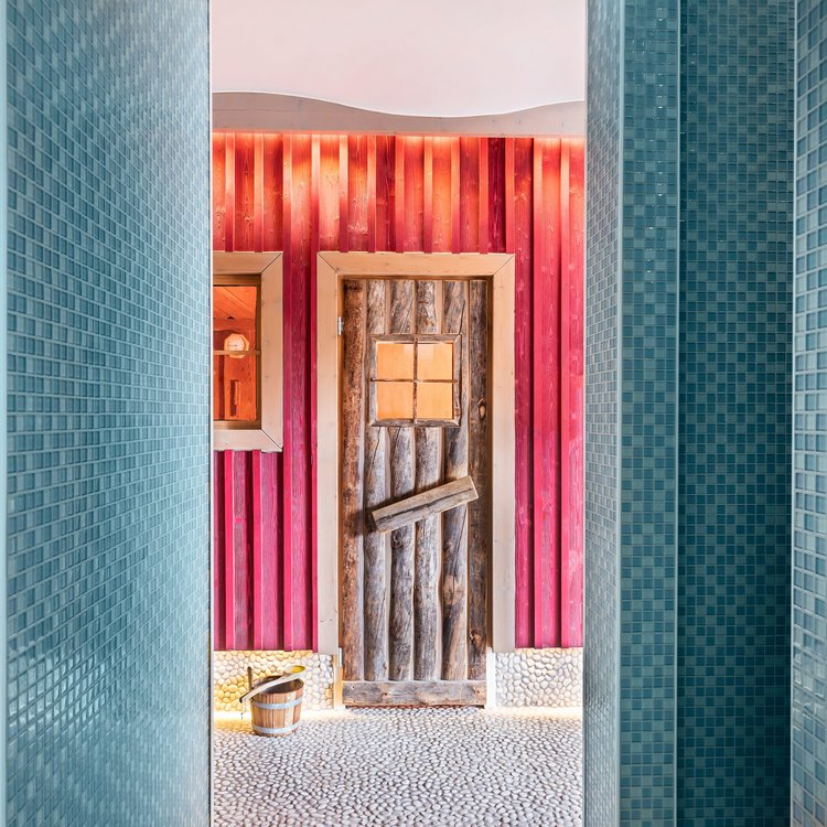 Blick aus der Dusche auf die farbenfrohe Saunahütte im Park-Hotel Hagenbeck