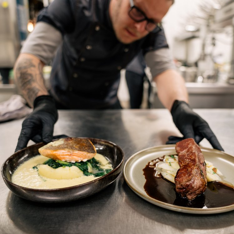Chef preparing artfully plated dishes in the kitchen of Park-Hotel Hagenbeck
