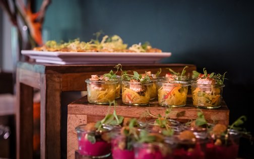 Fein angerichtete Vorspeisen im Glas auf rustikaler Holzplatte im Park-Hotel Hagenbeck
