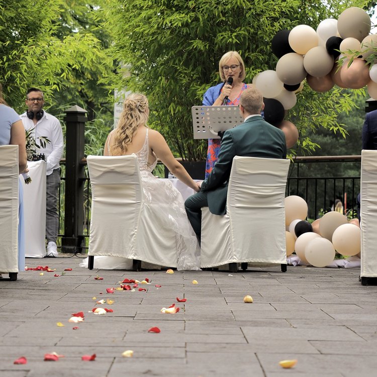 Das Brautpaar im Freien mit Lustballons und Rosenblättern