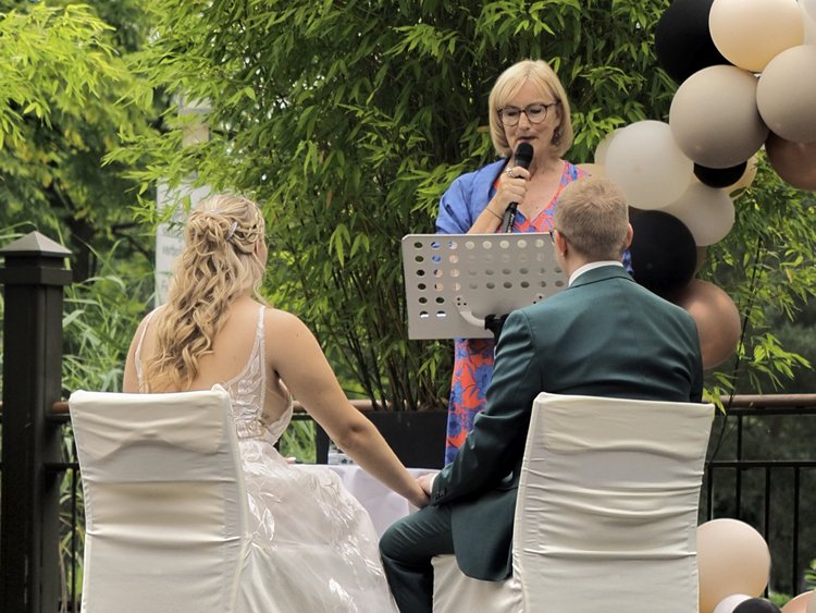 Das Brautpaar im Freien mit Lustballons und Rosenblättern