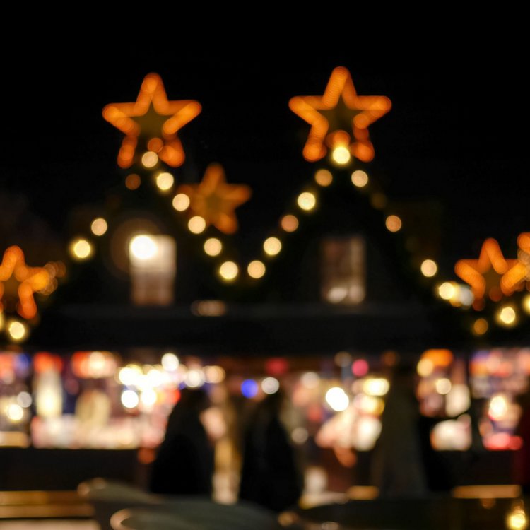 Beleuchteter Weihnachtsmarkt in Hamburg mit Stern-Deko am Abend – festliche Atmosphäre im Dunkeln